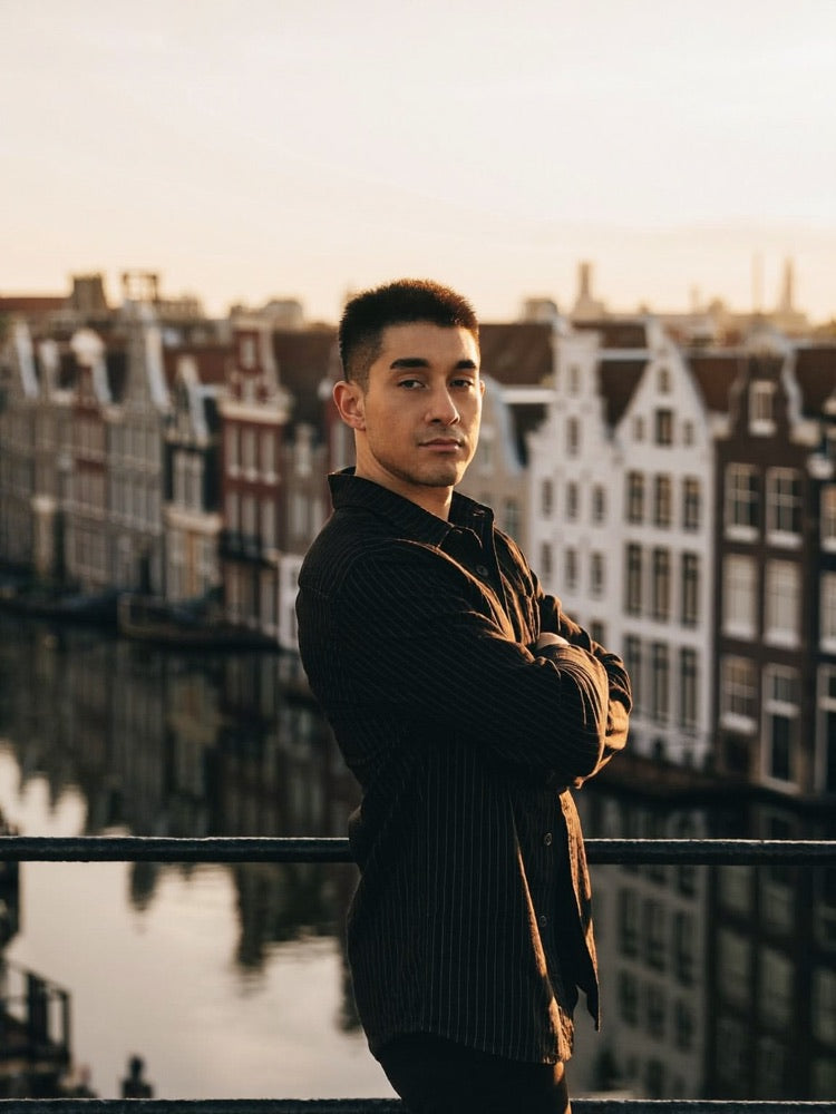 Ondernemer met uitzicht over een Amsterdamse gracht bij zonsondergang